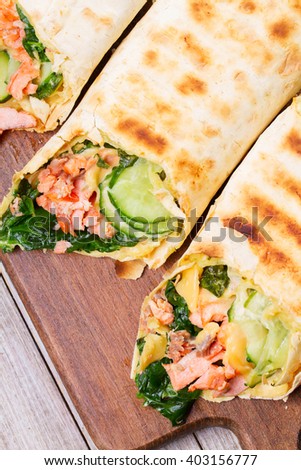 Salmon, Spinach, Cheese and Onion Burritos. View from above, top studio shot