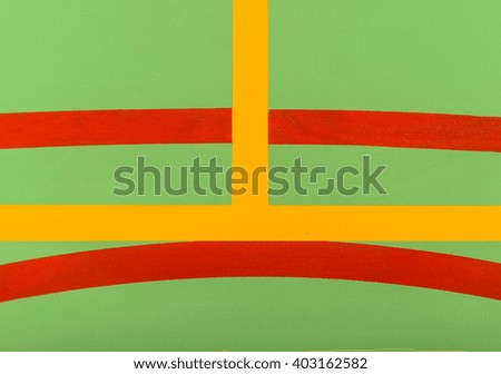 Colorful red, yellow and white markings on a green indoor sports court in an abstract background pattern ad texture