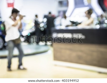 abstract blur photographers shooting a woman in motor show exhibition.