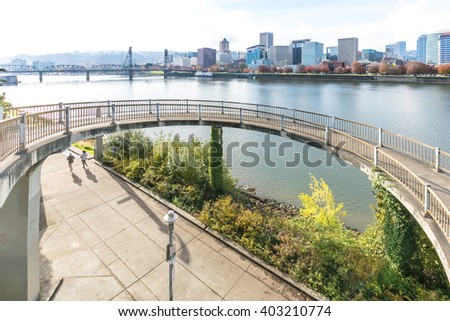 concrete footpath near water with cityscape and skyline in portland