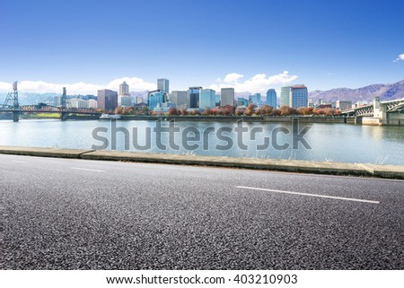 empty asphalt road near water with cityscape and skyline in portland
