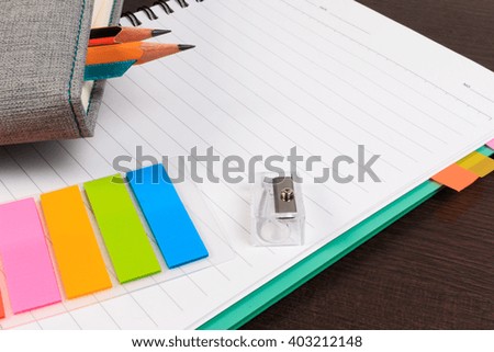 Notebook, paper note with pencil on wooden table.