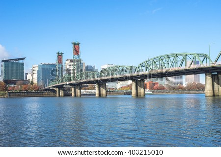 steel bridge over water with cityscape and skyline of portland 