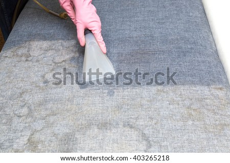 Dirty sofa chemical cleaning with professionally extraction method. Upholstered furniture. Early spring cleaning or regular clean up. Royalty-Free Stock Photo #403265218