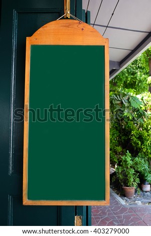Blackboard menu with easel on wooden table with blur coffee shop background, Copy space for adding your content