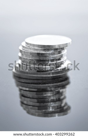a stack of silver coins with reflections on a black background