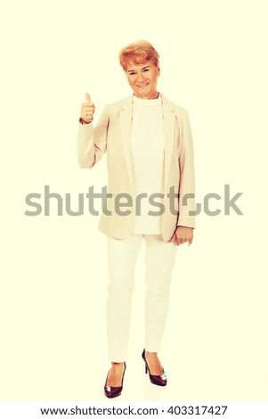 Smile elegant senior woman showing thumb up