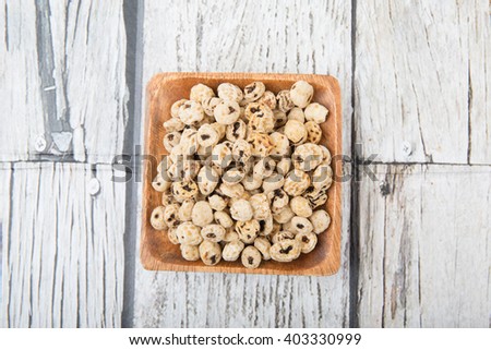Dried tiger nuts in wooden square bowl over wooden background