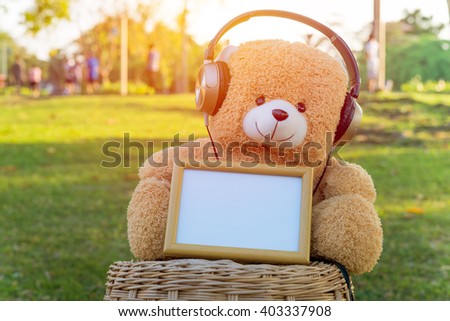 Toy bear ,headphone and frame in the public park