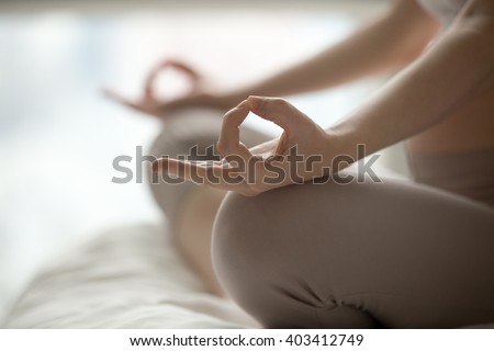 Close-up view of young beautiful woman doing morning yoga after waking up at home. Female model sitting cross-legged in Easy pose, Sukhasana posture and meditating. Working out on the bed. Motivation Royalty-Free Stock Photo #403412749