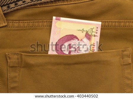 Iranian rials banknotes in jeans pocket