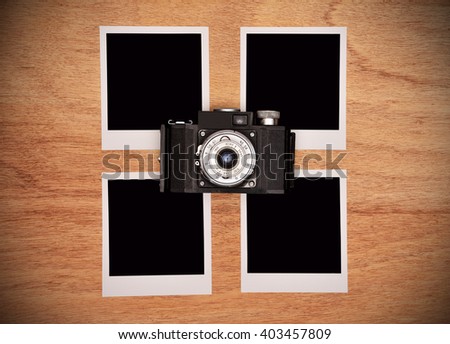 Vintage camera with four blank photo card on wooden table