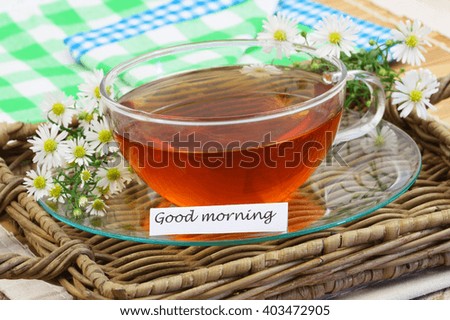 Good morning card with chamomile tea on wicker tray, closeup
