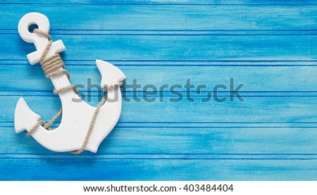 A white wood anchor on a blue background in business card proportions