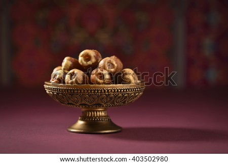 Fine quality ripen dates and an vintage plate. An ornamental bowl of Arabian dates. Royalty-Free Stock Photo #403502980
