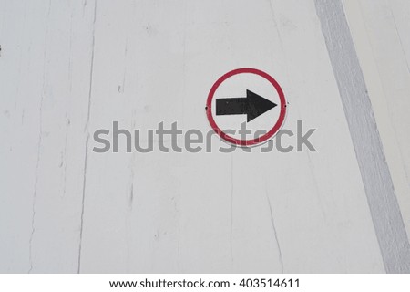 Right arrow sign on white wall