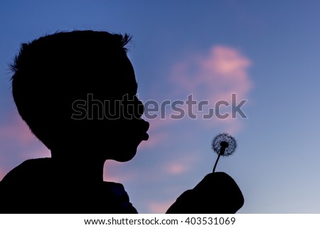 Profile of Boy Blowing Dandelion