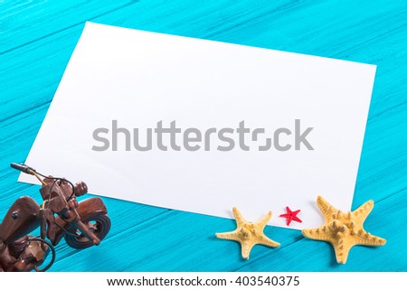 Marine items and empty tag on wooden background. Sea objects on turquoise painted wooden planks. Place for text. Selective focus.