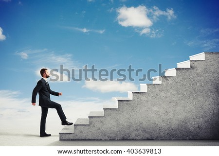 Man in a formal wear climbing concrete stairs in a light cloudy sky, side view