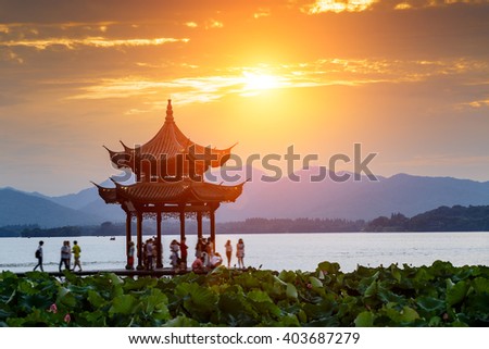 ancient pavilion of Hangzhou west lake at dusk, in China Royalty-Free Stock Photo #403687279