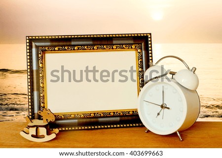 vintage frame and clock with blur sunrise and ocean background