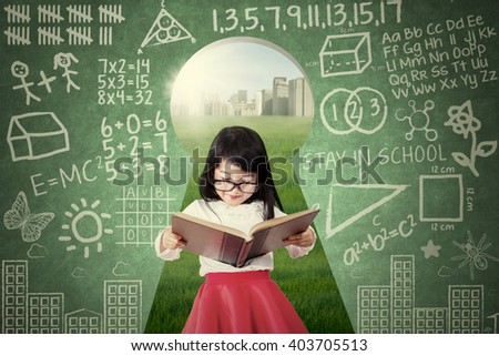 Picture of a cute female student reading a book while wearing glasses on the keyhole