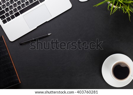 Office leather desk workplace table with laptop, coffee cup, notepad and plant. Top view with copy space