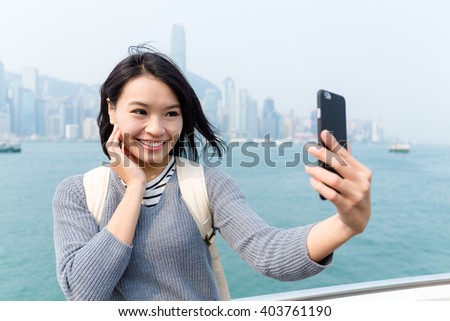 Woman take seflie by cellphone in Hong Kong