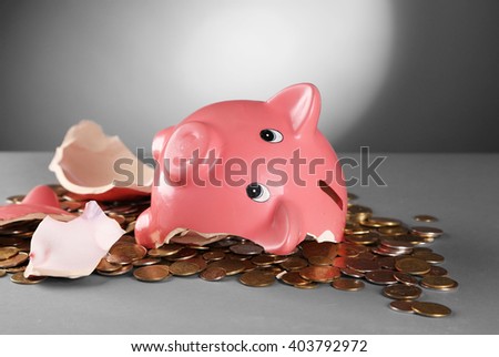Broken piggy bank on the table against grey background, close up