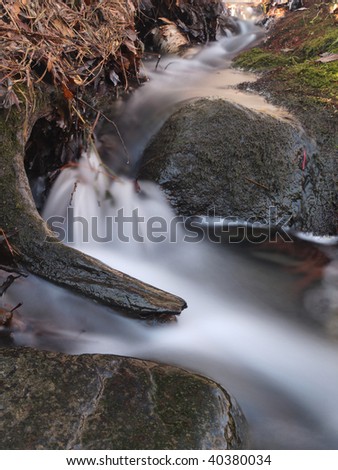 beautiful scene in the forest during autumn. Slow shutter speed to blur flowing water.
