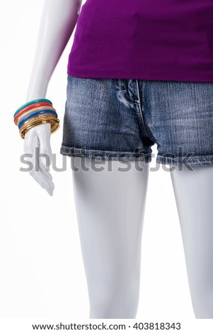 Short shorts and bracelet set. Mannequin wearing colorful bracelet set. Lady's summer shorts in stock. Simple patterns and warm colors.