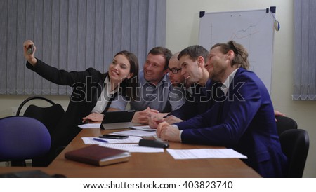 Business people making face while taking selfie in office. Smartphone