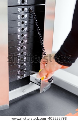 Closeup of a young man selecting the weight while working out