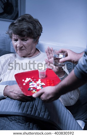 Picture of an old woman refusing to take her medication