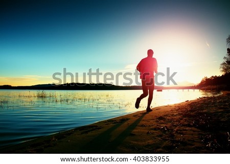 Tall man in running cloths  at amazing sunset in sport and healthy lifestyle concept and jogging cross country training workout
