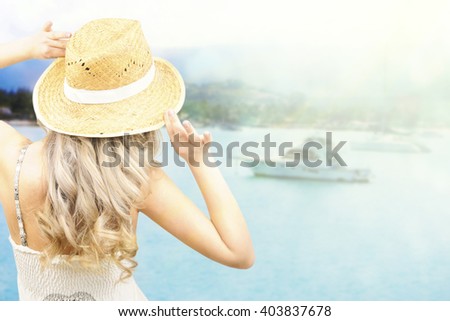 Beautiful girl in a hat looking at the sea