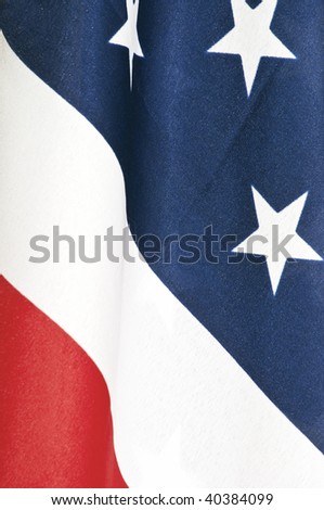 Closeup of an American flag showing the red, white and blue with some of the stars.