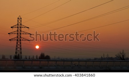 Electrical transmission tower, Energy transport, road transport. Against Sunset