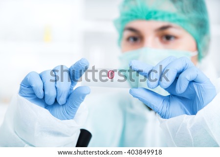 woman in a laboratory microscope with microscope slide in hand.toned image.. Royalty-Free Stock Photo #403849918