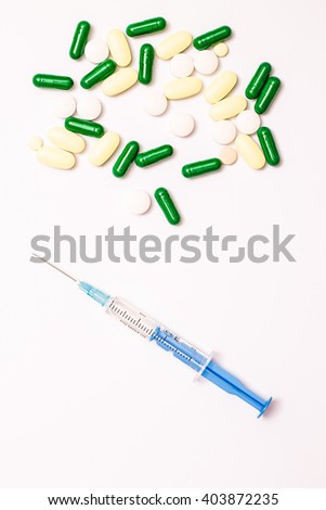 Medicine pills or capsules with syringe on white background. Drug prescription for treatment medication. Pharmaceutical medicament, cure in container for health. Antibiotic, painkiller or narcotic