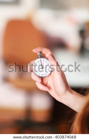 Woman holds stopwatch in hand, close up