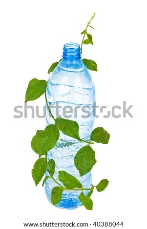 bottle with clean blue water drink and green foliage