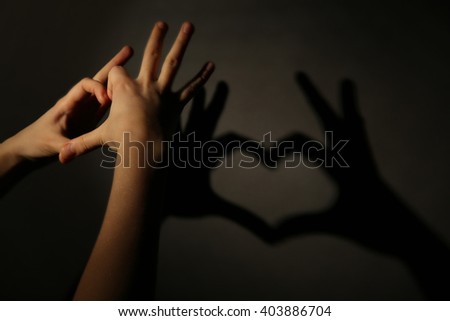 Hand shaped heart on dark background
