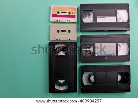 Set of old audio and video cassettes on turquoise background