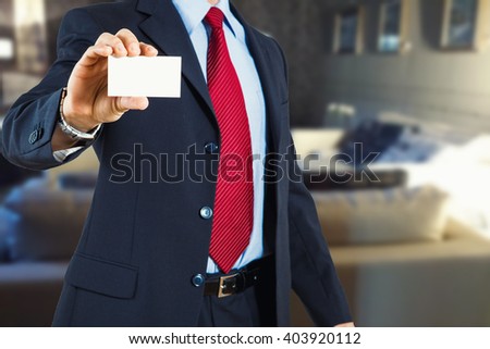 Man in the office showing business card in hand