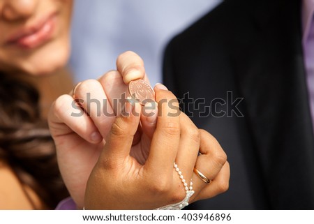Close up capture of an newlywed hands holding and old happy coin 