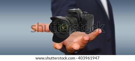 Young man holding modern digital camera in his hand