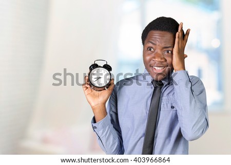 black man holding an alarm clock