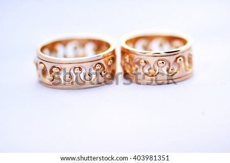 two gold wedding rings on a white background closeup