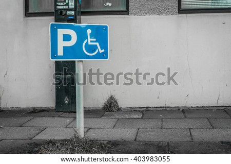 Handicap parking sign on a street in front of a building